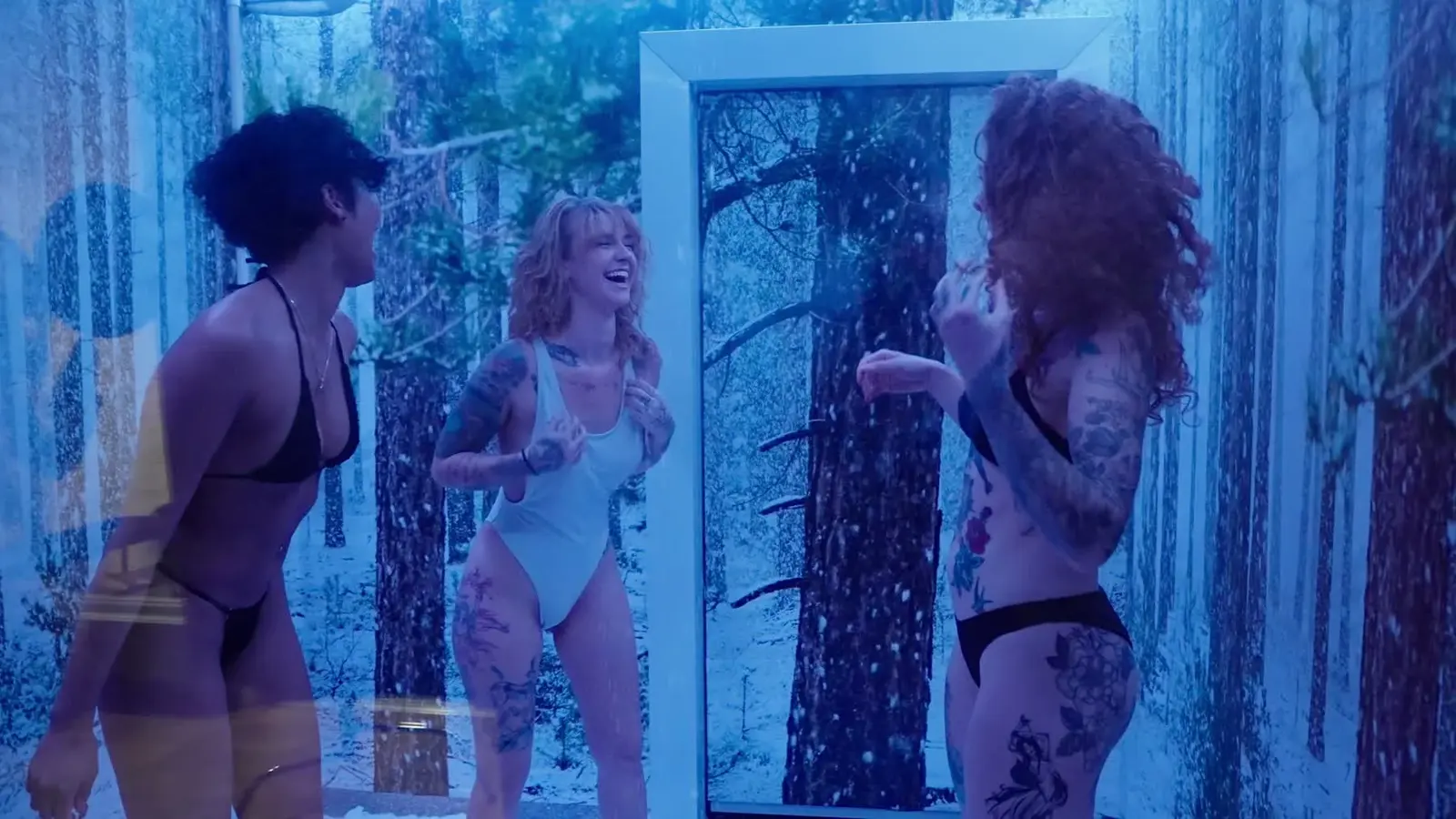 Guests laughing inside the blue-lit snow room in the finished Cleopatra's Rituals commercial.