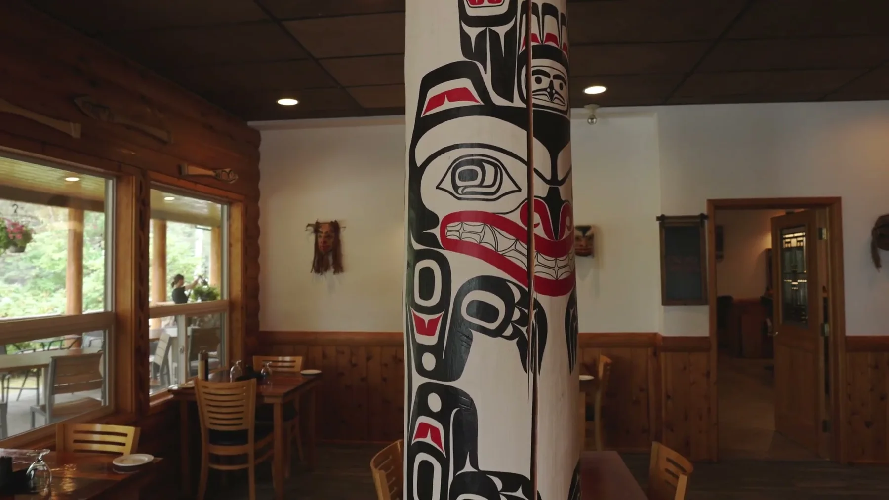 A carved pole stands inside the wood-lined Haida House lodge.