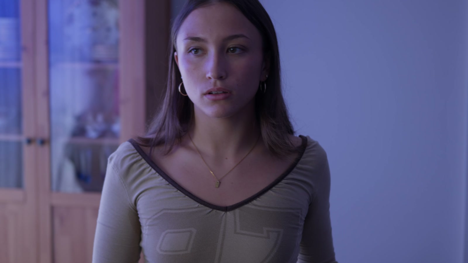 A lead performer looks to the side in a cool-toned close-up from Jamie.