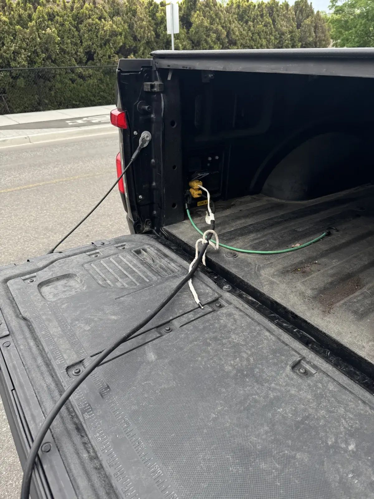 A power cable runs from the open tailgate of a Ford F-150 Lightning.