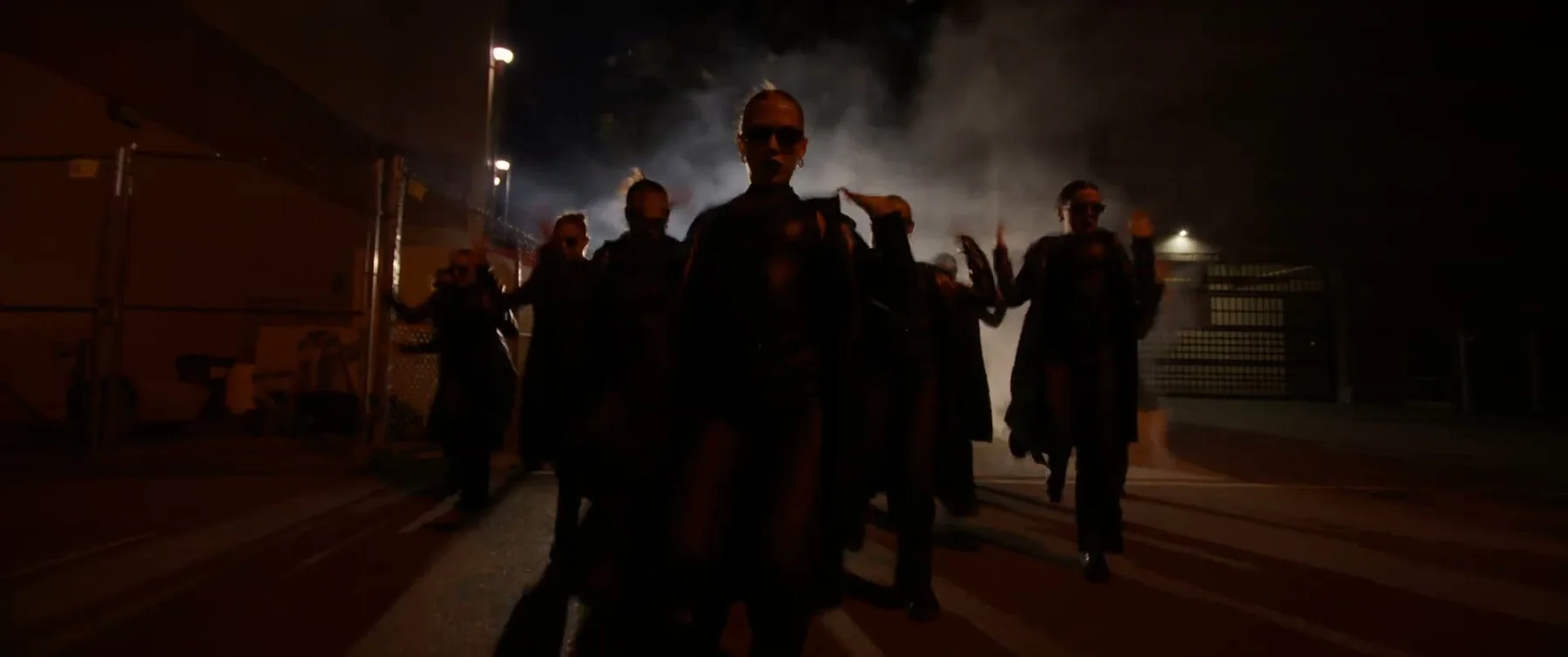 Sockeye 2025 ensemble walks forward through a dim industrial space.