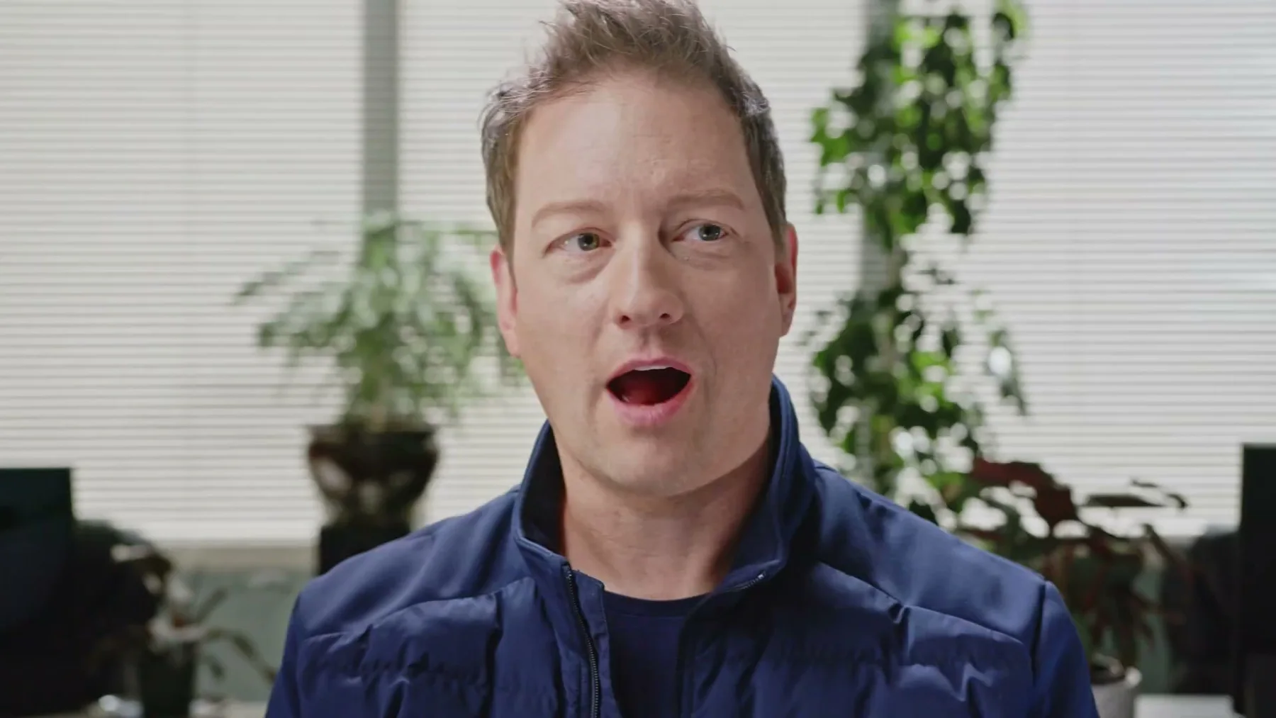 A Gneiss Stuff team member in a blue jacket speaks from the office.